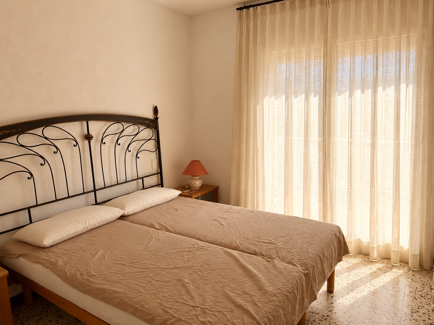Dormitorio cálido con cortinas translúcidas